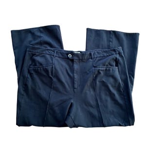 May include: Black wide-leg trousers with a button fastening and pockets.