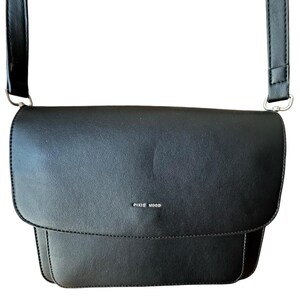 May include: Black leather crossbody bag with a silver buckle and the text "PIXIE MOOD" on the front.