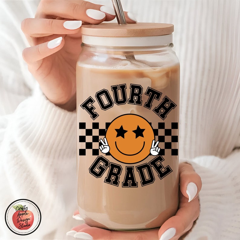 May include: A clear glass tumbler with a wooden lid and a black and orange design that says "FOURTH GRADE" with a smiley face with stars for eyes.