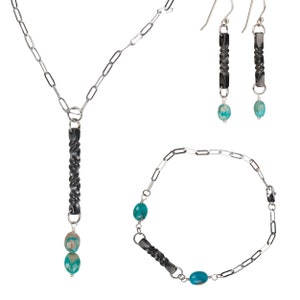 May include: A silver chain necklace, bracelet and earrings set with turquoise stones and black twisted metal accents.