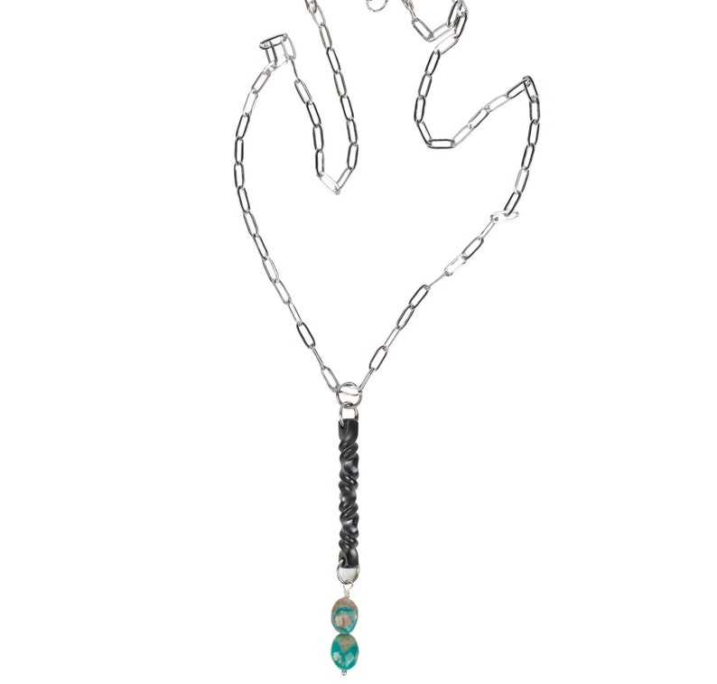 iron twist pendant with two turquoise stone drop on a stainless steel paperclip style chain with white background.