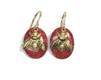 Tiny bees on bright red glitter ovals