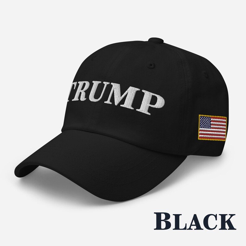 May include: Black baseball cap with white embroidered text "TRUMP" and a small American flag patch on the side.