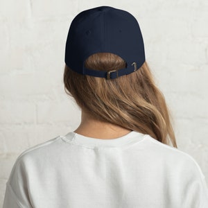 May include: A navy blue baseball cap with an adjustable strap in the back.