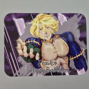 May include: Rectangular sticker featuring an anime-style illustration of a muscular character with blonde hair and blue and gold armor. The text "Poseidon Happy Birthday" is written in a stylized font.