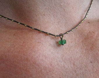 Tiny emerald green faceted rondelle charm on daintiest crocheted beaded necklace with brown and gold strand