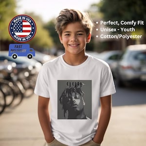 May include: White youth t-shirt with a black and white image of a rapper with the text "999" above the image.