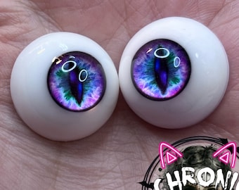 Peut inclure: Une paire d'yeux de poupée réalistes avec un iris violet, bleu et vert. Les yeux sont blancs avec un bord noir autour de l'iris.