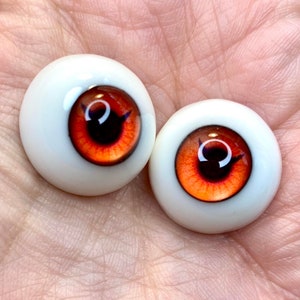 May include: Two realistic-looking orange and black doll eyes with a white sclera.