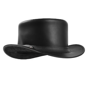 May include: A black leather top hat with a wide brim and a band around the crown. The hat has a classic, formal design, suitable for costumes or special events. The hat is made of a smooth, shiny leather.