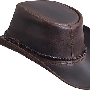 Puede incluir: Sombrero de vaquero de cuero marr&oacute;n con ala ligeramente curvada y banda trenzada alrededor de la corona. El sombrero tiene un acabado envejecido. Un sombrero de estilo western cl&aacute;sico.