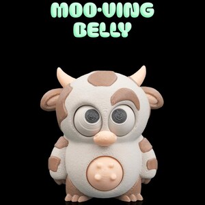 Könnte beinhalten: Eine 3D-gedruckte Kuhfigur mit weiß-braun geflecktem Körper, zwei Hörnern und großen Augen. Der Text MOO-VING BELLY ist in Hellgrün über der Figur gedruckt. Die Kuh hat ein rundes, hellrosa Bauchmerkmal und einen einfarbigen schwarzen Hintergrund.