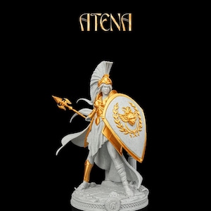 May include: A gray and gold figurine of a warrior wearing a crested helmet, holding a spear and a shield with a central emblem. The figure stands on a circular base with a small helmet icon. The text ATENA is printed in gold above the figurine.