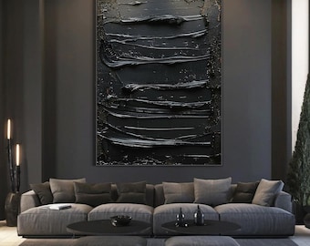 Puede incluir: Pintura abstracta en blanco y negro con gruesos trazos de pincel. La pintura está enmarcada y colgada en una pared oscura en un salón.