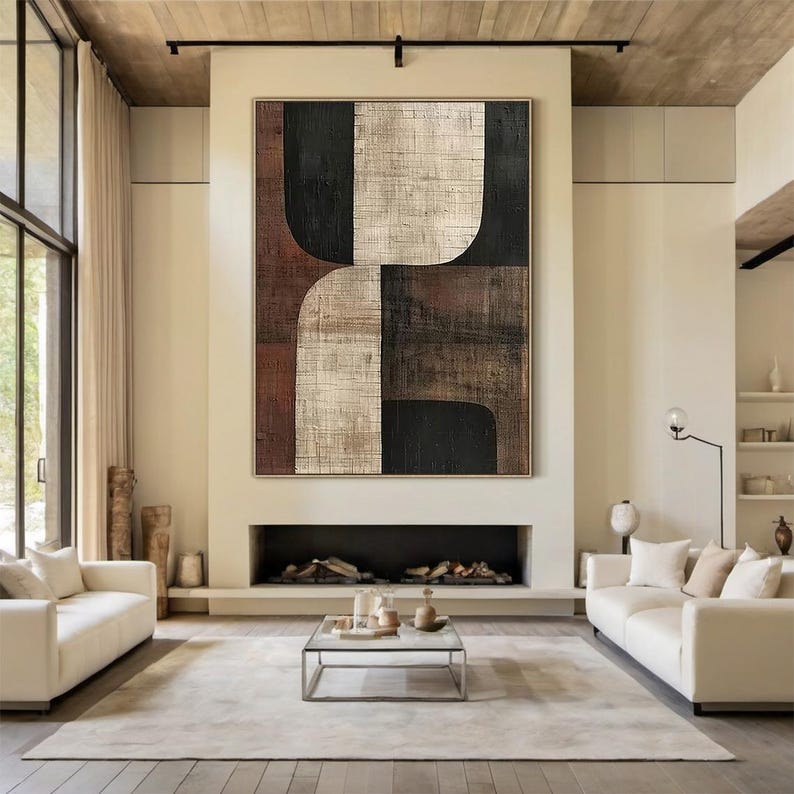 May include: Abstract geometric painting with brown, black, and white colors. The painting is on a canvas and has a textured surface. The painting is hanging on a wall in a living room.