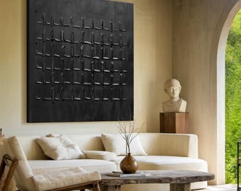 May include: A black and white abstract painting with a grid pattern. The painting is hanging on a wall in a living room with a white couch and a wooden coffee table.
