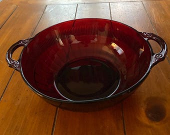 May include: A red glass bowl with two handles. The bowl has a textured surface and is empty.