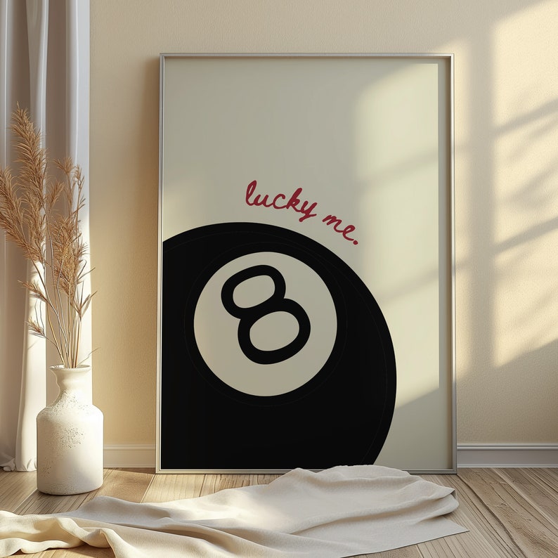 May include: A black and white illustration of a pool ball with the number 8 on it. The text "lucky me." is written in red cursive above the ball.