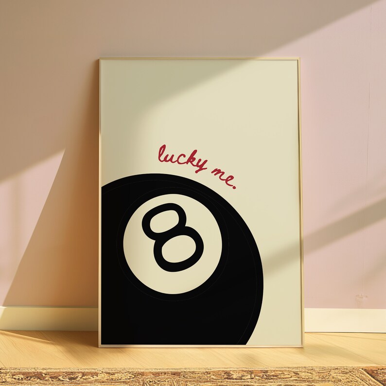 May include: A black and white illustration of a pool ball with the number eight inside. The text "lucky me." is written in red cursive above the ball.