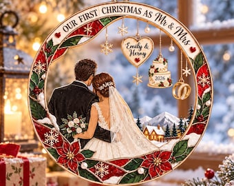 May include: A round Christmas ornament featuring a couple in wedding attire, with the text Our First Christmas as Mr & Mrs. It includes hanging charms of a heart with the names Emily & Herny, a wedding cake with 2026, and gold rings.
