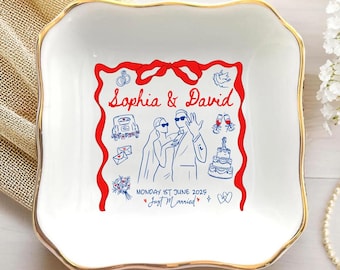 May include: White ceramic square dish with a gold rim, featuring a red and blue illustration of a wedding scene. The text "Sophia & David" is displayed above the illustration, with the date "Monday 1st June 2025" and "Just Married" below.