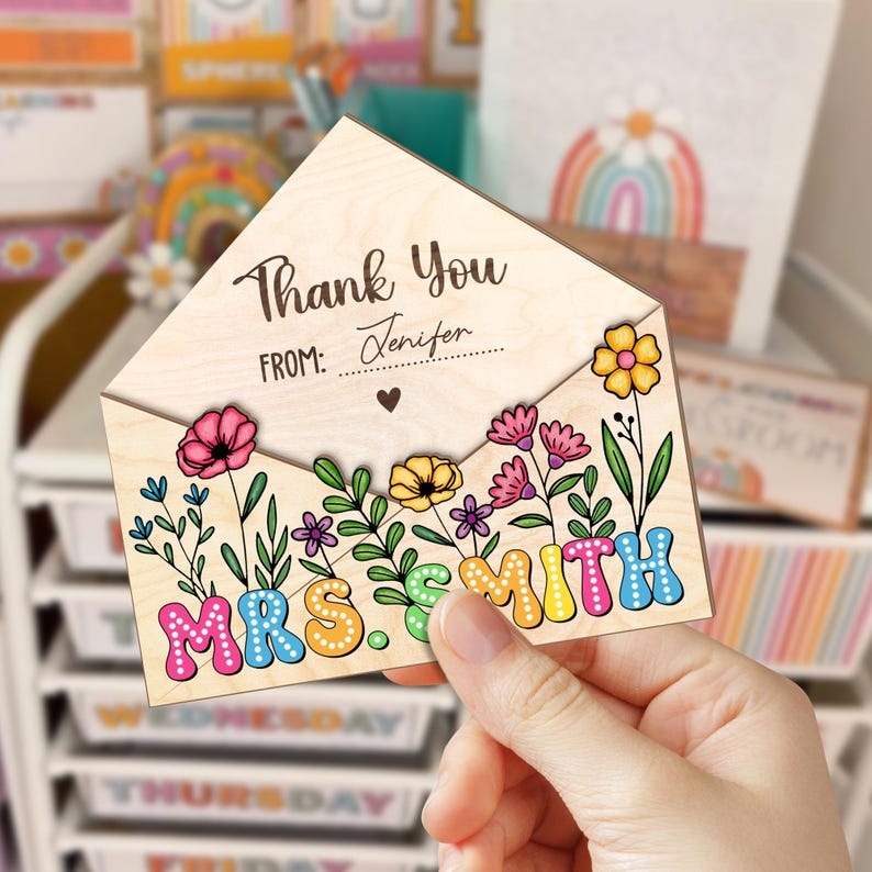 May include: Wooden thank you card with a floral design and the text "Thank You" and "Mrs. Smith". The card is shaped like an envelope and has a space for a name to be written in.