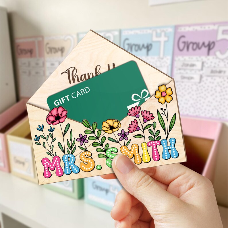 May include: Wooden envelope with a gift card inside. The envelope is decorated with colorful flowers and the text "Thank You Mrs. Smith".