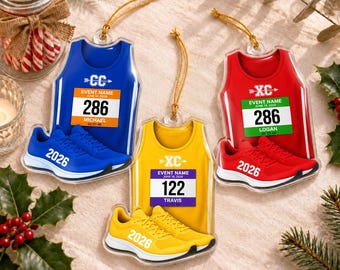 May include: Three flat acrylic ornaments shaped like athletic tank tops and running shoes. One is blue with number 286 and name Michael, one is yellow with number 122 and name Travis, and one is red with number 286 and name Logan. All feature 2026.