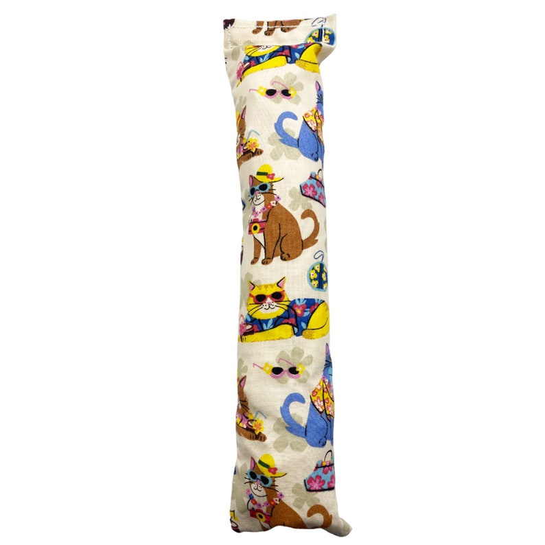 May include: A beige catnip toy shaped like a long pillow with a repeating pattern of cats wearing sunglasses and tropical shirts.