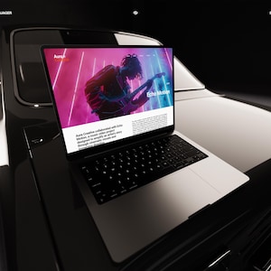 K&ouml;nnte beinhalten: Ein Laptop, der eine Website mit dem Text "Echo Motion" und einer Person, die Gitarre spielt, vor einem rosa und blauen Hintergrund anzeigt. Der Laptop befindet sich auf der Motorhaube eines schwarzen Autos. Der Website-Text lautet "Aura Creative hat mit Echo Motion zusammengearbeitet..."