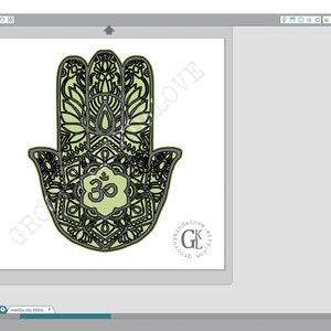 Puede incluir: Un dise&ntilde;o de mano de hamsa negro y verde con detalles intrincados y un s&iacute;mbolo om en el centro. El dise&ntilde;o est&aacute; listo para ser cortado con una Silhouette Cameo.