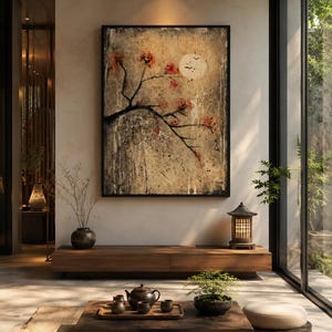 May include: A rectangular framed wall art piece featuring a textured beige and grey background with a dark tree branch, red blossoms, and a pale moon. The artwork hangs above a low wooden console table in a room with a tea set and floor cushions.