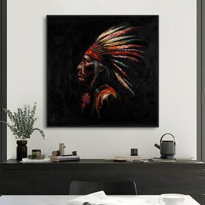 May include: A square framed oil painting depicting a profile view of a person wearing a traditional feathered headdress. The artwork features a dark black background with vibrant red, yellow, and teal accents on the feathers and clothing.