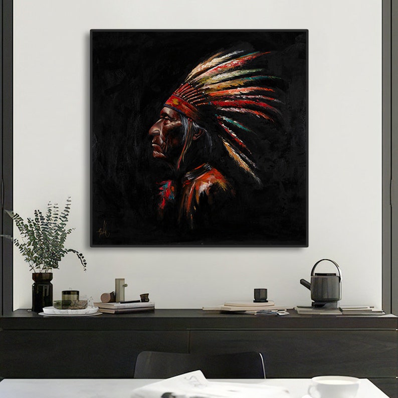 May include: A square framed oil painting depicting a profile view of a person wearing a traditional feathered headdress. The artwork features a dark black background with vibrant red, yellow, and teal accents on the feathers and clothing.