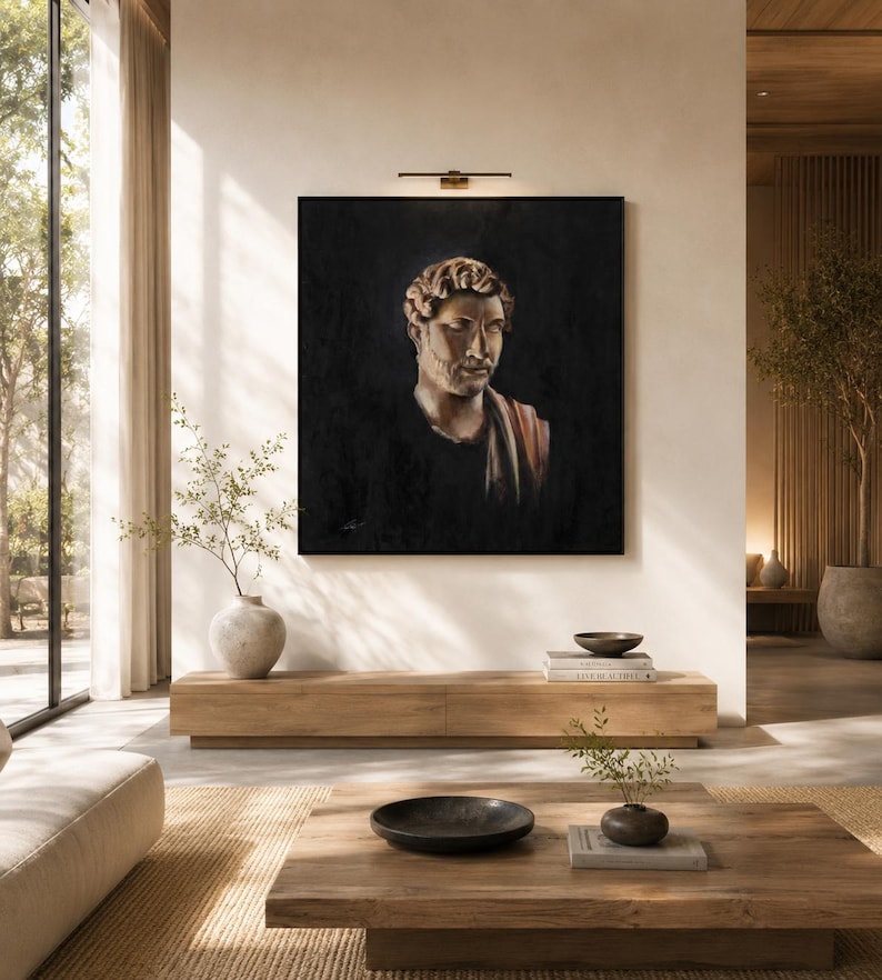 May include: A square framed oil painting depicting a classical Roman-style bust of a person with curly hair and a draped garment, set against a dark, moody background. The artwork is mounted on a light-colored wall above a wooden console table.