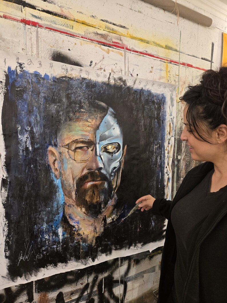 May include: A large square painting on canvas featuring a portrait of a man with a beard and glasses. The left side shows a realistic human face, while the right side depicts a metallic, robotic skull with a glowing yellow eye against a dark background.