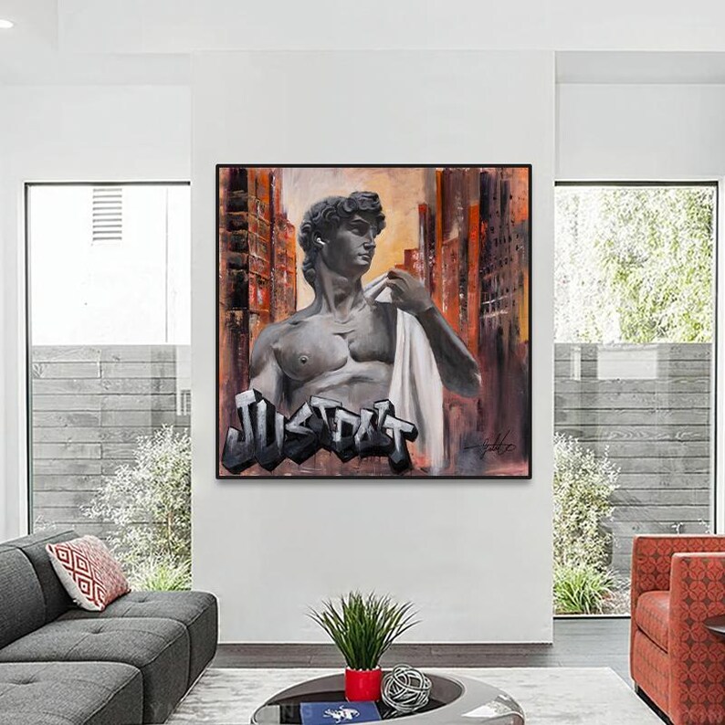 May include: A square canvas painting featuring a grayscale bust of a classical male figure draped in white fabric, set against an abstract background of orange and dark brown vertical lines, with the word JUST OUT in bold black graffiti lettering.