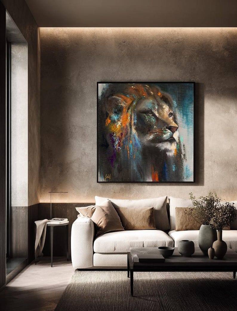 May include: A square wall art piece featuring an abstract oil painting of a lion's head in profile. The artwork uses a dark color palette with vibrant streaks of orange, blue, and purple paint, set within a thin black frame on a textured wall.