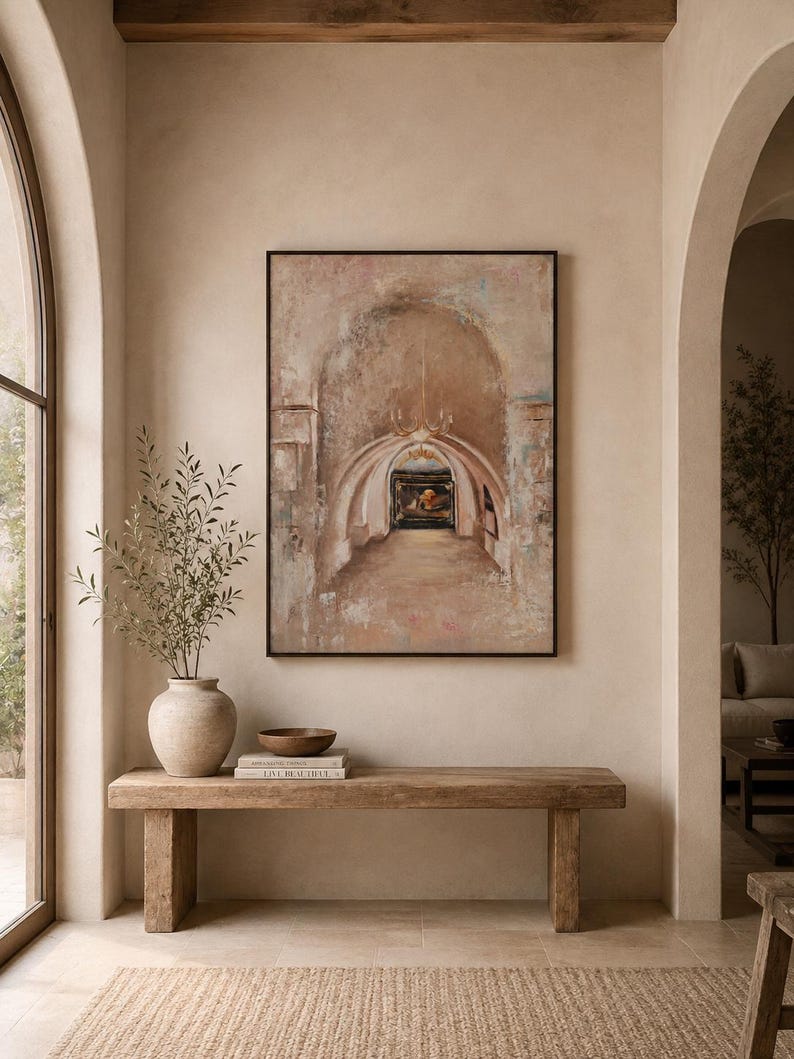 May include: A rectangular framed wall art piece depicting an arched stone hallway with a chandelier and a dark doorway. The artwork features muted beige, brown, and soft blue tones with a textured, weathered appearance in a black frame.
