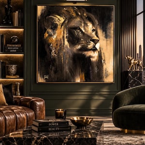 Op de afbeelding: Een vierkant wandkunstwerk met een gedetailleerd olieverfschilderij van een leeuwenkop in profiel. Het kunstwerk gebruikt een palet van diepzwart, antraciet en metallic goudtinten met zichtbare penseelstreken, ingelijst in een dunne goudkleurige metalen lijst.