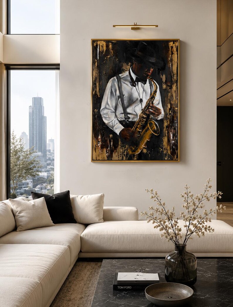 May include: A framed wall art piece depicting a musician wearing a hat, white shirt, and suspenders while playing a gold saxophone. The painting features a dark, textured background with gold accents, presented in a thin gold frame on a wall.