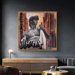 May include: A painting of a statue of a man with a white cloth draped over his shoulder. The statue is in front of a cityscape with the word "JUST DO IT" painted in graffiti style on the ground.