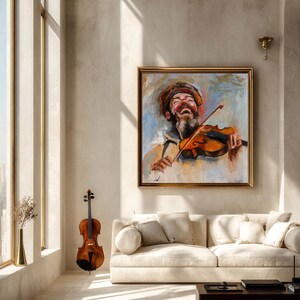 Puede incluir: Una pintura al &oacute;leo cuadrada en un marco dorado que representa a una persona barbuda con sombrero tocando el viol&iacute;n con un rostro expresivo. La obra presenta pinceladas visibles en tonos naranja, marr&oacute;n y azul sobre una pared clara.