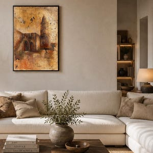 May include: A rectangular wall art piece in a black frame featuring an abstract, textured painting of a tall tower and building structure in shades of gold, brown, and deep orange, with a distressed, weathered finish across the entire surface.