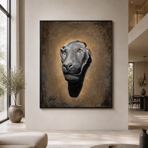 May include: A framed rectangular wall art piece featuring a dark, sculptural lion head centered against a textured, golden-brown background. The lion is rendered in shades of black and grey, creating a high-contrast focal point within the frame.