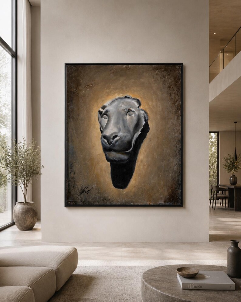 May include: A framed rectangular wall art piece featuring a dark, sculptural lion head centered against a textured, golden-brown background. The lion is rendered in shades of black and grey, creating a high-contrast focal point within the frame.