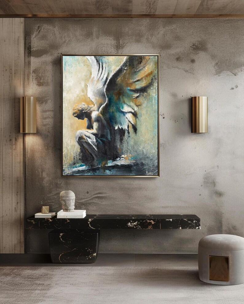 Op de afbeelding: Een rechthoekig ingelijst kunstwerk aan de muur met een olieverfschilderij van een zittende engel met grote, getextureerde vleugels. Het kunstwerk gebruikt een palet van diepblauw, antracietgrijs en warme gouden accenten, met een peinzende figuur.