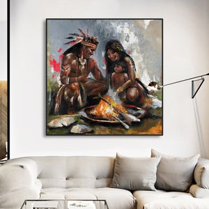 May include: An oil painting on canvas depicting a family of three gathered around a campfire. The figures are rendered in warm earth tones with visible brushstrokes. The scene features a person in a feathered headdress, another person, and a child.