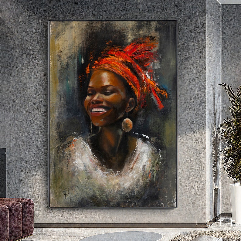 Op de afbeelding: Een schilderij van een vrouw met een donkere huidskleur die een feloranje hoofddoek en een wit shirt draagt. Ze glimlacht en heeft een grote, ronde oorbel in haar linker oor.