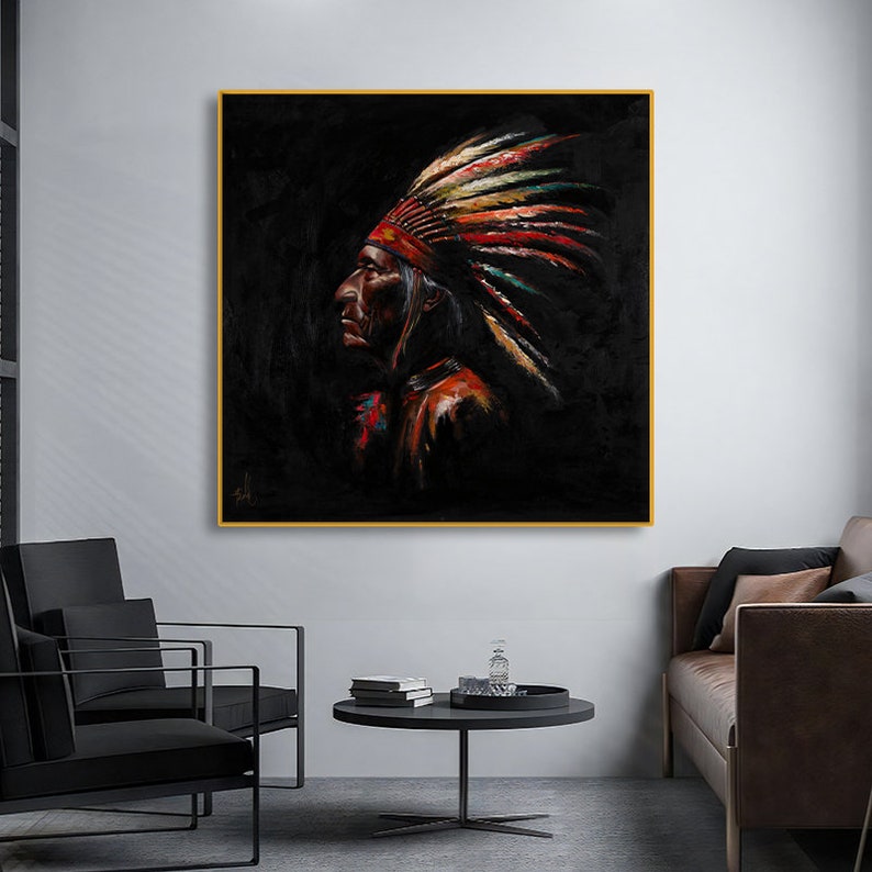 May include: A square wall art piece featuring a profile portrait of an Indigenous person wearing a vibrant, multi-colored feathered headdress against a solid black background. The painting uses textured brushstrokes in red, yellow, and blue tones.